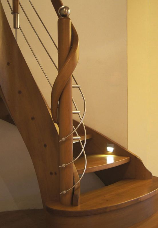 Drewniane schody gięte z balustradą z elementami metalu