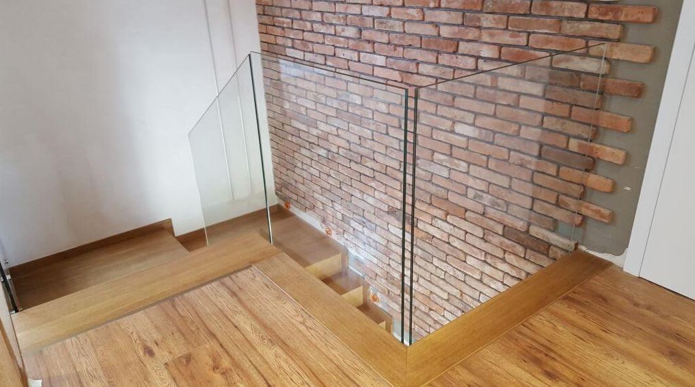 Szklana balustrada przy drewnianych schodach