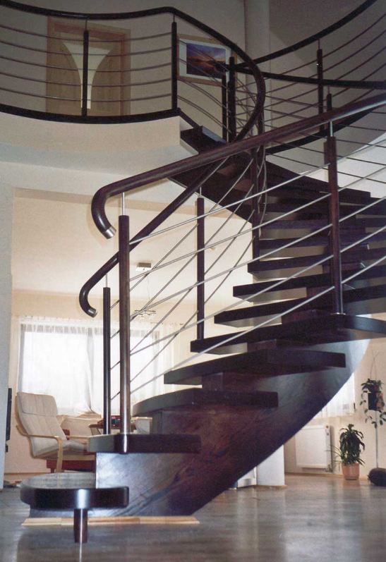 Drewniane schody kręte z balustradą z elementami metalu