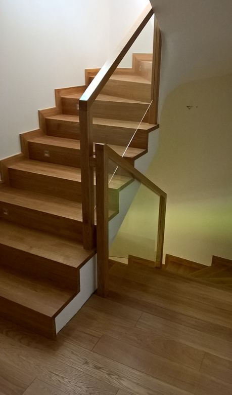 Drewniane schody z balustradą szklaną z elementami drewna