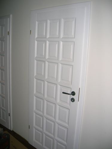 Białe drzwi wewnątrz domu jednorodzinnego