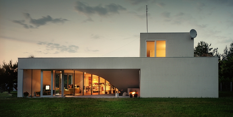 Oświetlenie domu nowoczesnego z płaskim dachem  - Domu Outrialnego - podkreśla jego prostą i nowoczesną bryłę